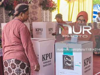 People participate in the simultaneous regional election at a polling station in Semarang, Central Java Province, on November 27, 2024. Indo...