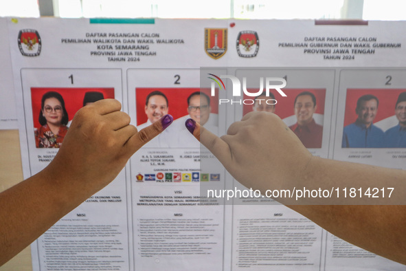 A person shows her inked finger after casting her vote during the simultaneous regional election in Semarang, Central Java Province, on Nove...