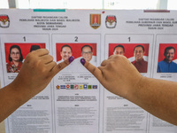 A person shows her inked finger after casting her vote during the simultaneous regional election in Semarang, Central Java Province, on Nove...