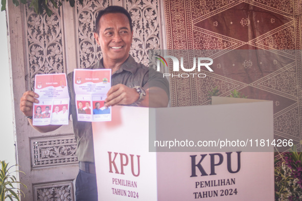 Central Java Province's gubernatorial candidate and former TNI Commander General Andika Perkasa shows the ballot papers while voting at a si...