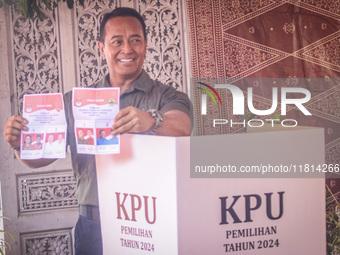 Central Java Province's gubernatorial candidate and former TNI Commander General Andika Perkasa shows the ballot papers while voting at a si...