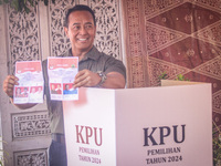 Central Java Province's gubernatorial candidate and former TNI Commander General Andika Perkasa shows the ballot papers while voting at a si...