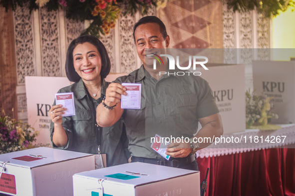 Central Java Province's gubernatorial candidate and former TNI Commander General Andika Perkasa shows the ballot papers while voting at a si...