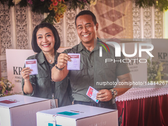 Central Java Province's gubernatorial candidate and former TNI Commander General Andika Perkasa shows the ballot papers while voting at a si...