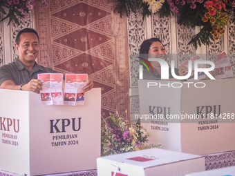 Central Java Province's gubernatorial candidate and former TNI Commander General Andika Perkasa shows the ballot papers while voting at a si...