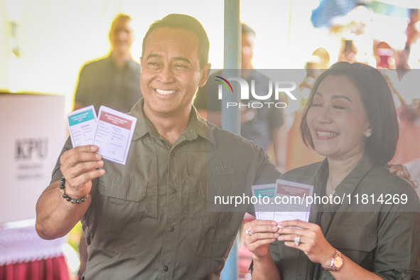 Central Java Province's gubernatorial candidate and former TNI Commander General Andika Perkasa shows the ballot papers while voting at a si...