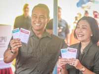 Central Java Province's gubernatorial candidate and former TNI Commander General Andika Perkasa shows the ballot papers while voting at a si...