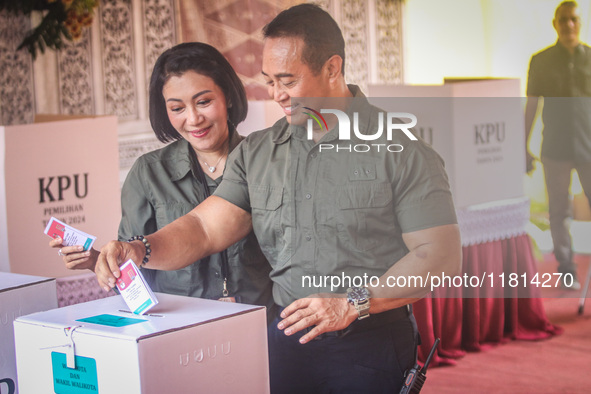 Central Java Province's gubernatorial candidate and former TNI Commander General Andika Perkasa shows the ballot papers while voting at a si...