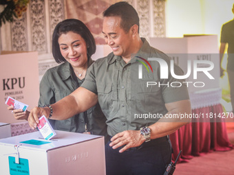 Central Java Province's gubernatorial candidate and former TNI Commander General Andika Perkasa shows the ballot papers while voting at a si...