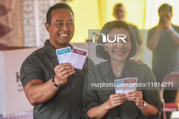 Central Java Province's gubernatorial candidate and former TNI Commander General Andika Perkasa shows the ballot papers while voting at a si...