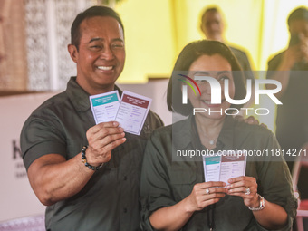 Central Java Province's gubernatorial candidate and former TNI Commander General Andika Perkasa shows the ballot papers while voting at a si...