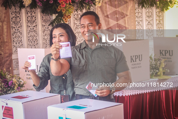 Central Java Province's gubernatorial candidate and former TNI Commander General Andika Perkasa shows the ballot papers while voting at a si...