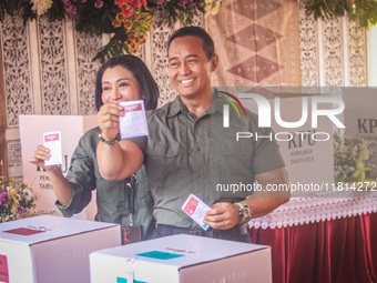 Central Java Province's gubernatorial candidate and former TNI Commander General Andika Perkasa shows the ballot papers while voting at a si...