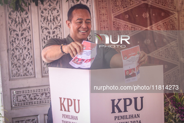 Central Java Province's gubernatorial candidate and former TNI Commander General Andika Perkasa shows the ballot papers while voting at a si...