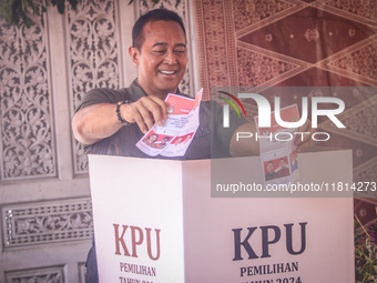 Central Java Province's gubernatorial candidate and former TNI Commander General Andika Perkasa shows the ballot papers while voting at a si...