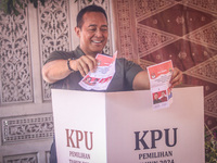 Central Java Province's gubernatorial candidate and former TNI Commander General Andika Perkasa shows the ballot papers while voting at a si...