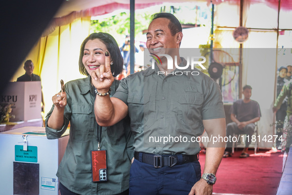 Central Java Province's gubernatorial candidate and former TNI Commander General Andika Perkasa shows the ballot papers while voting at a si...