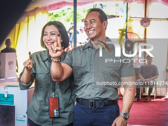 Central Java Province's gubernatorial candidate and former TNI Commander General Andika Perkasa shows the ballot papers while voting at a si...