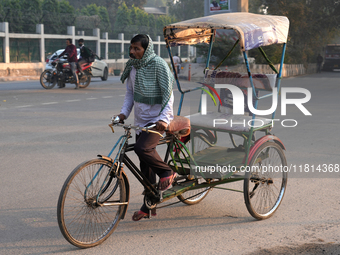 A rickshaw puller covers his face with a scarf as air pollution levels remain in the ''very poor'' category in New Delhi, India, on November...