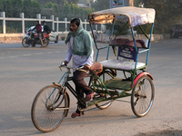 A rickshaw puller covers his face with a scarf as air pollution levels remain in the ''very poor'' category in New Delhi, India, on November...