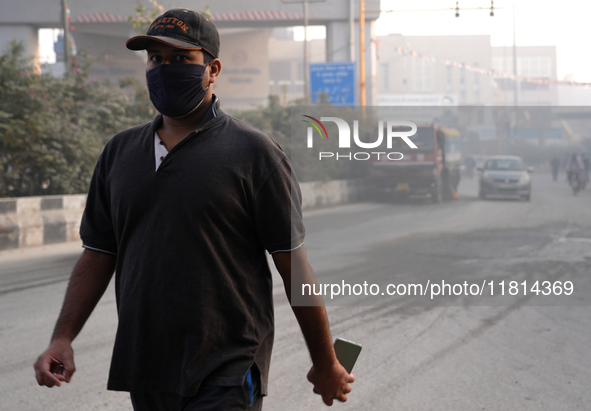 A man wearing a face mask walks as New Delhi, India, is covered in a thick layer of toxic haze on November 26, 2024. 