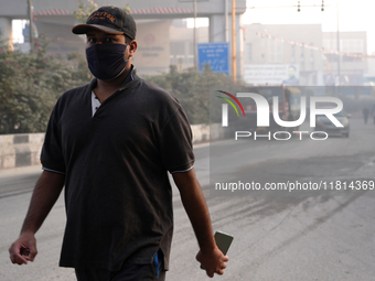 A man wearing a face mask walks as New Delhi, India, is covered in a thick layer of toxic haze on November 26, 2024. (