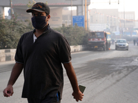 A man wearing a face mask walks as New Delhi, India, is covered in a thick layer of toxic haze on November 26, 2024. (