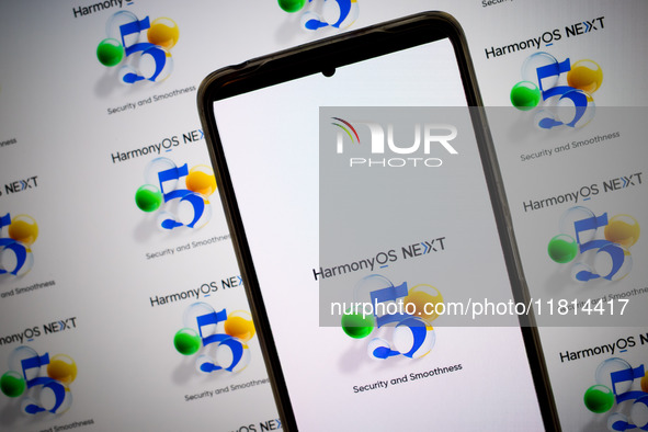 The logo of the Huawei HarmonyOS NEXT operating system appears on a smartphone screen and on a computer screen as a background in this photo...