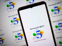 The logo of the Huawei HarmonyOS NEXT operating system appears on a smartphone screen and on a computer screen as a background in this photo...