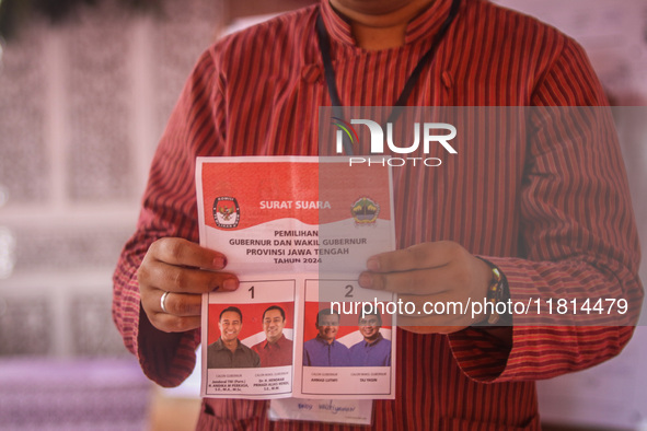 An election staffer counts ballots at a polling station in Semarang, Central Java Province, on November 27, 2024, after Indonesians vote to...