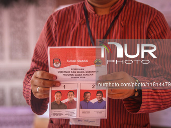 An election staffer counts ballots at a polling station in Semarang, Central Java Province, on November 27, 2024, after Indonesians vote to...