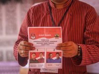 An election staffer counts ballots at a polling station in Semarang, Central Java Province, on November 27, 2024, after Indonesians vote to...