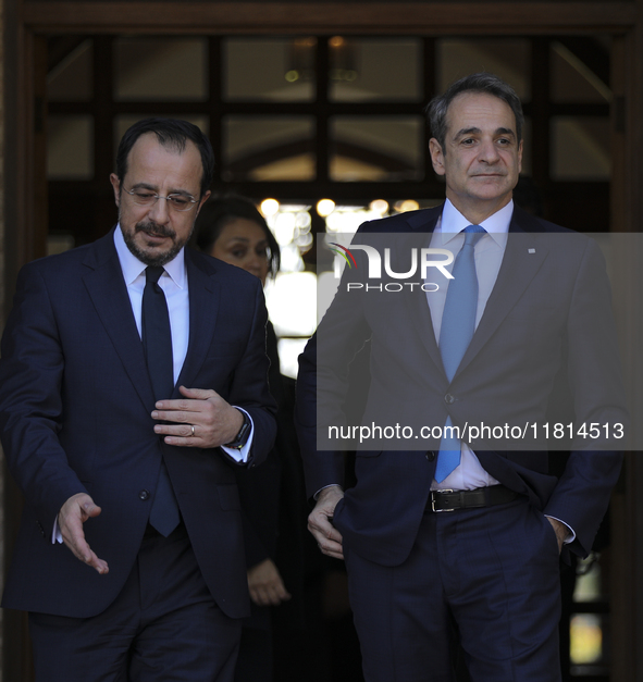 Cyprus' President Nikos Chirstodoulides, left, and Greece's Prime Minister Kyriakos Mitsotakis talk during a meeting at the presidential pal...