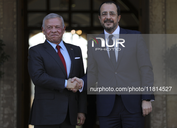 Cyprus' President Nikos Christodoulides, right, and the Jordan's King Abdullah II bin al-Hussein shake hands before a meeting at the Preside...