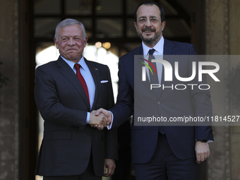 Cyprus' President Nikos Christodoulides, right, and the Jordan's King Abdullah II bin al-Hussein shake hands before a meeting at the Preside...