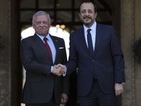 Cyprus' President Nikos Christodoulides, right, and the Jordan's King Abdullah II bin al-Hussein shake hands before a meeting at the Preside...