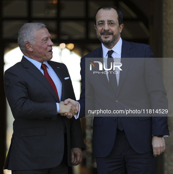 Cyprus' President Nikos Christodoulides, right, and the Jordan's King Abdullah II bin al-Hussein shake hands before a meeting at the Preside...