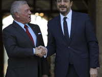 Cyprus' President Nikos Christodoulides, right, and the Jordan's King Abdullah II bin al-Hussein shake hands before a meeting at the Preside...