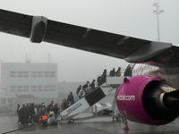 People board Wizz Air plane on the foggy morning at the airport in Balice near Krakow, Poland on November 27, 2024. (