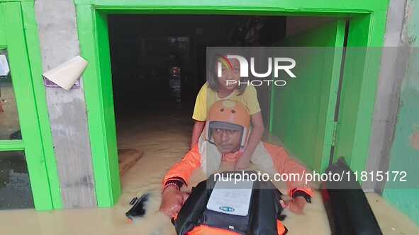 An officer from the Indonesian National SAR Agency carries out rescues for children and residents who are victims of flooding in Medan, Nort...