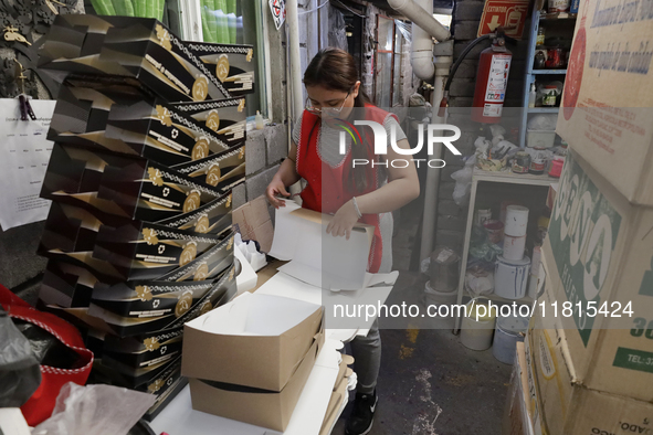 A worker unfolds boxes to place handmade balls made of blown glass for sale in a workshop and family cooperative located in the Tlahuac muni...