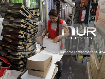 A worker unfolds boxes to place handmade balls made of blown glass for sale in a workshop and family cooperative located in the Tlahuac muni...