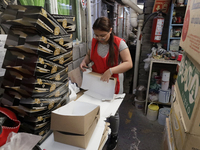 A worker unfolds boxes to place handmade balls made of blown glass for sale in a workshop and family cooperative located in the Tlahuac muni...