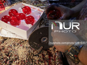 Craftsmen cut handcrafted balls made of blown glass for sale in the Tlahuac municipality, Mexico City, on Christmas Eve and New Year in Mexi...