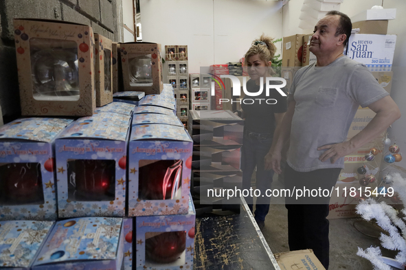 People look at handcrafted spheres at a cooperative workshop made of blown glass for sale in Tlahuac municipality, Mexico City, on November...