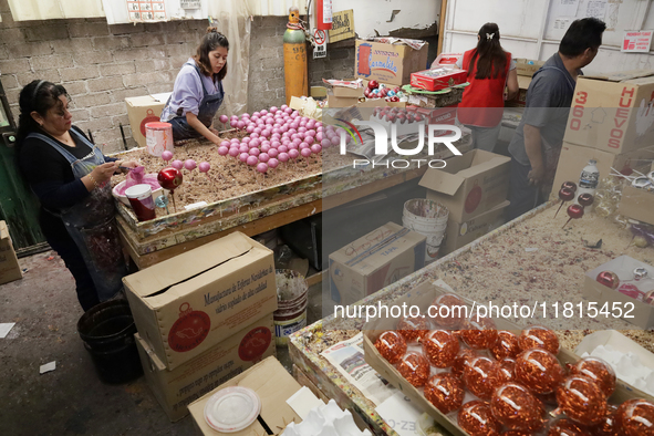 Inside a workshop and cooperative in the Tlahuac municipality, Mexico City, artisans make spheres from blown glass for sale on Christmas and...