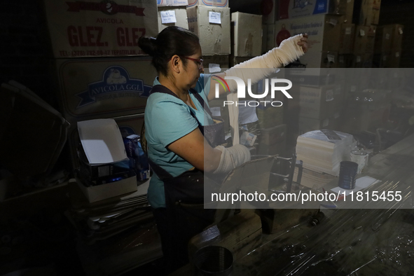 Josefina Aguilar, an industrial biochemist, puts on bandages before making handcrafted balls made of blown glass for sale in the Tlahuac mun...