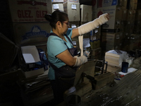 Josefina Aguilar, an industrial biochemist, puts on bandages before making handcrafted balls made of blown glass for sale in the Tlahuac mun...