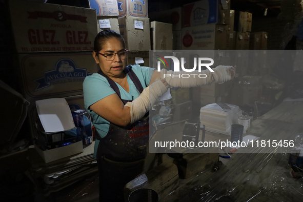 Josefina Aguilar, an industrial biochemist, puts on bandages before making handcrafted balls made of blown glass for sale in the Tlahuac mun...