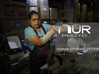 Josefina Aguilar, an industrial biochemist, puts on bandages before making handcrafted balls made of blown glass for sale in the Tlahuac mun...